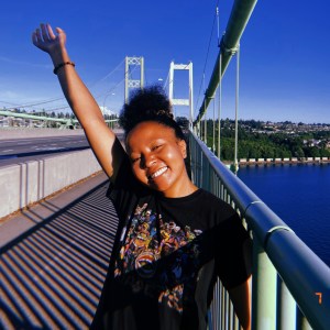 girl holding up arm on bridge